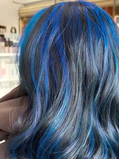 Dark hair with bright cobalt blue through it, in soft waves